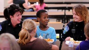 Ibrahim Ibrahim kept his third-grade classmates at Kennedy entertained while enjoying lunch with two officers, Cmdr. Amy Vokal (left) and officer Melissa Myers. Ibrahim and Myers have become good friends after meeting at Ibrahimâ€™s Mankato apartment complex.