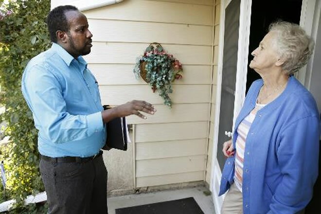 Abdul Kulane, a Somali-American running for the St. Cloud City Council seat in Ward 1, talks with Gloria Jones, 72, at her home in St. Cloud on Wednesday, September 17, 2014. Photo: Leila Navidi 
